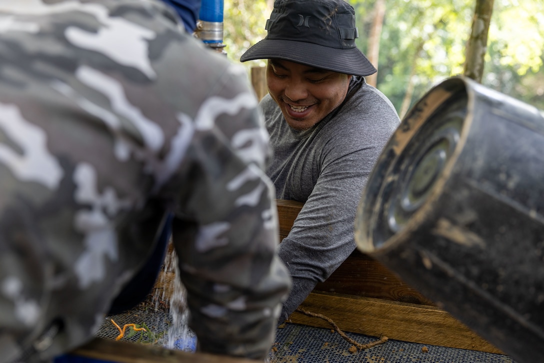 U.S. Army Staff Sgt. Somvang Xayphengsy, center, a recovery NCO, assigned to a Defense POW/MIA Accounting Agency recovery team, wet screens during a recovery mission in Laos, March 16 2026.