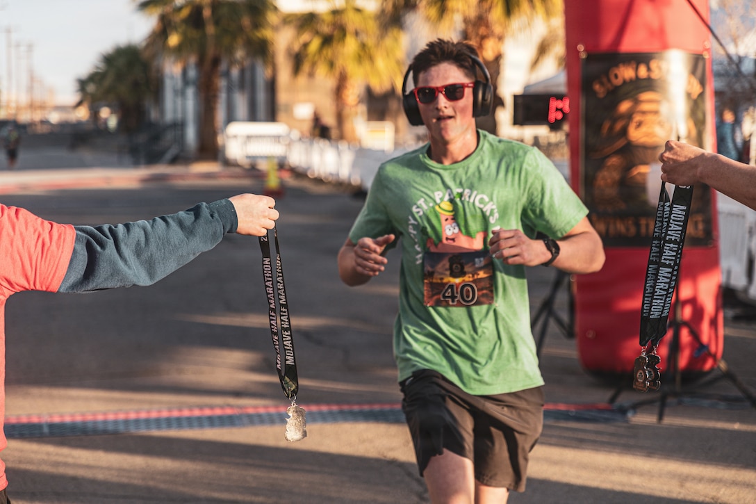A participant receives a medal after completing the Mojave Half Marathon at Marine Corps Air Ground Combat Center, Twentynine Palms, California, March 14, 2026. The Mojave Half Marathon marked the first ever 13.1-mile race aboard the installation, it challenged runners to improve their physical fitness as they ran through the desert, while encouraging camaraderie within the community of MCAGCC. (U.S. Marine Corps photo by Lance Cpl. Emilio Murphy)