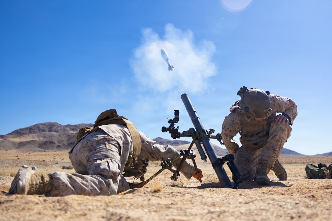 U.S. Marine Corps Lance Cpl. Freddy Britomacas, left, and Cpl. Cruz Testerman, both mortarmen with 1st Battalion, 2nd Marine Regiment, 2nd Marine Division, conduct mortar drills using an M224 60mm mortar at Range 106, as part of Service Level Training Exercise 3-26 at Marine Corps Air Ground Combat Center, Twentynine Palms, California, April 1, 2026. SLTE is designed to be a challenging, realistic training environment that produces combat-ready forces capable of operating as an integrated Marine Air Ground Task Force. (U.S. Marine Corps photo by Pfc. Ethan DePaul)