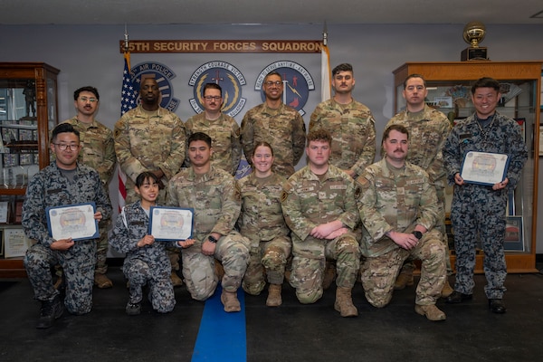 U.S. Air Force Military Working Dog handlers assigned to the 35th Security Forces Squadron and Japan Air Self-Defense Force security forces K-9 handlers assigned to the 3rd and 4th Air Wings pose for a group photo at the end of a joint bilateral K-9 exercise at Misawa Air Base, Japan, April 10, 2026.