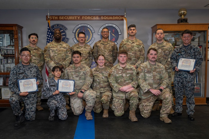 U.S. Air Force Military Working Dog handlers assigned to the 35th Security Forces Squadron and Japan Air Self-Defense Force security forces K-9 handlers assigned to the 3rd and 4th Air Wings pose for a group photo at the end of a joint bilateral K-9 exercise at Misawa Air Base, Japan, April 10, 2026.