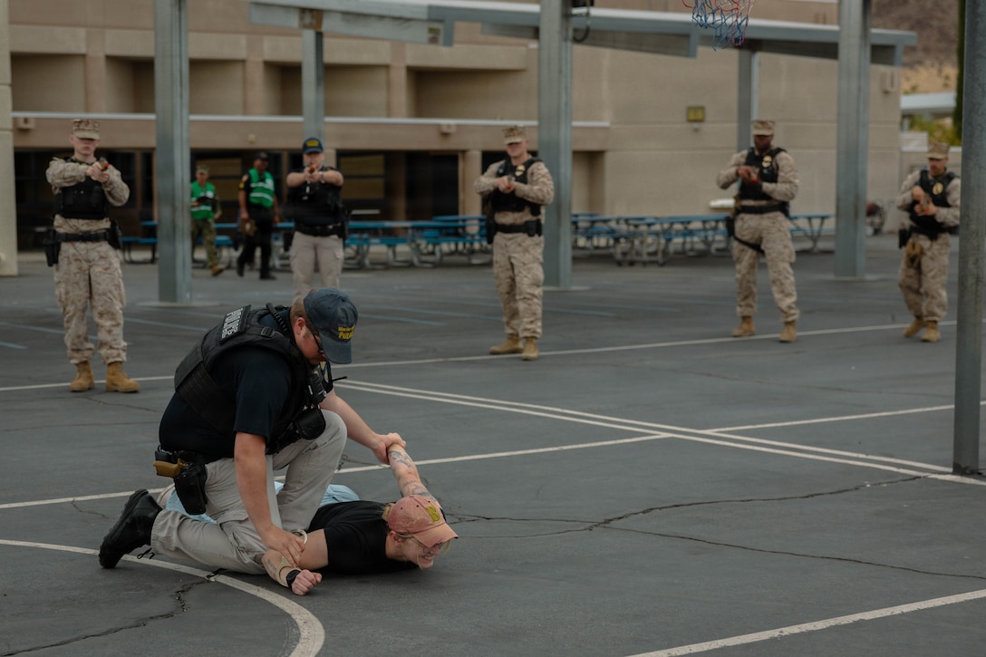 U.S. Marine Corps Sgt. Taylor Tenley, Wisconsin native, explosive ordnance disposal technician with Marine Corps Air Ground Combat Center, acts as an active shooter and simulates a detainment during the active shooter drill at Condor Elementary School, Twentynine Palms, California, March 31, 2026. This exercise simulated an active shooter threat in order to better prepare Marines in case of a real word scenario. (U.S. Marine Corps photo by Lance Cpl. Gracelyn Hanson)