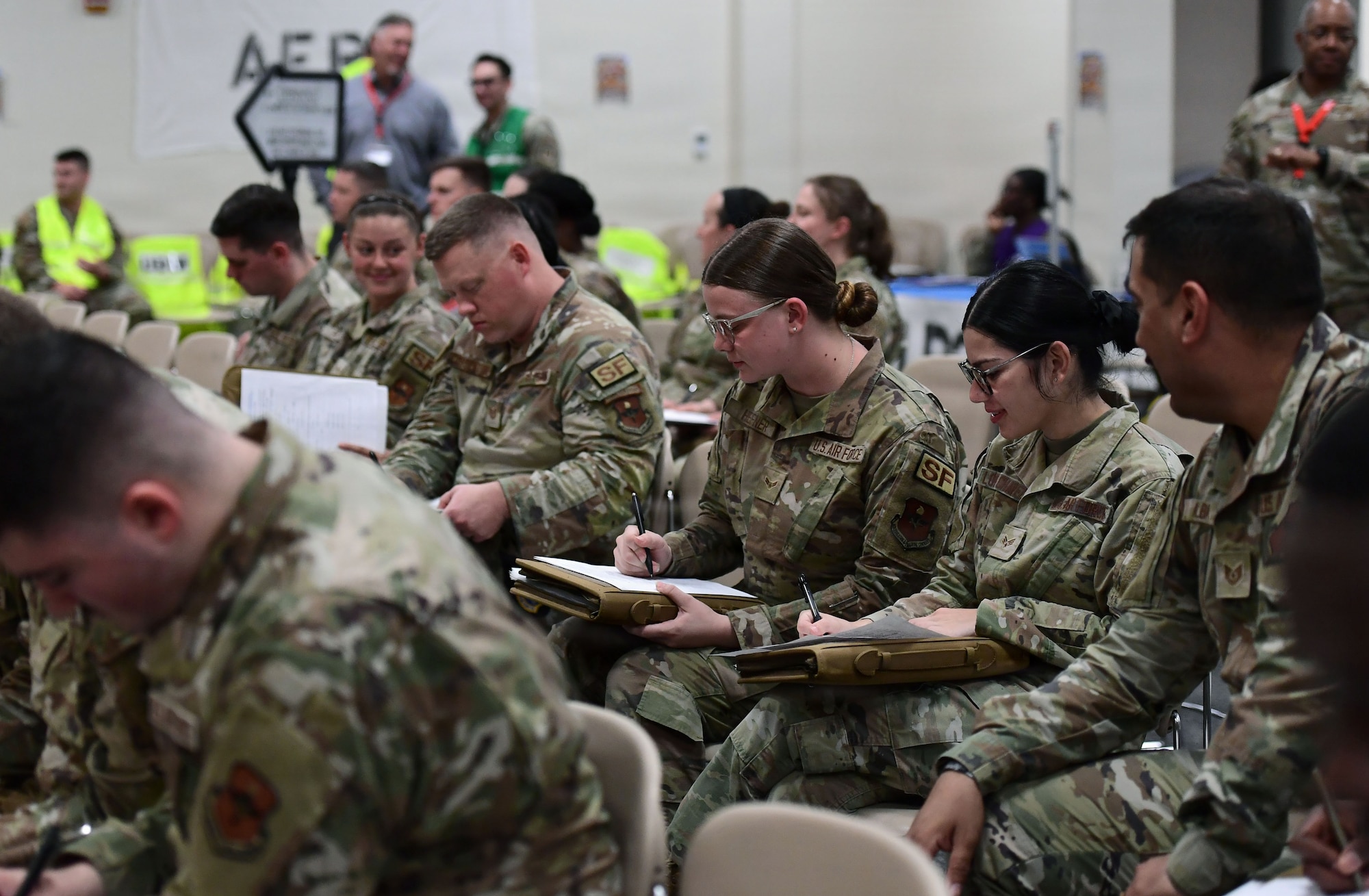 personnel in military uniforms sit in folding chairs to fill our paperwork