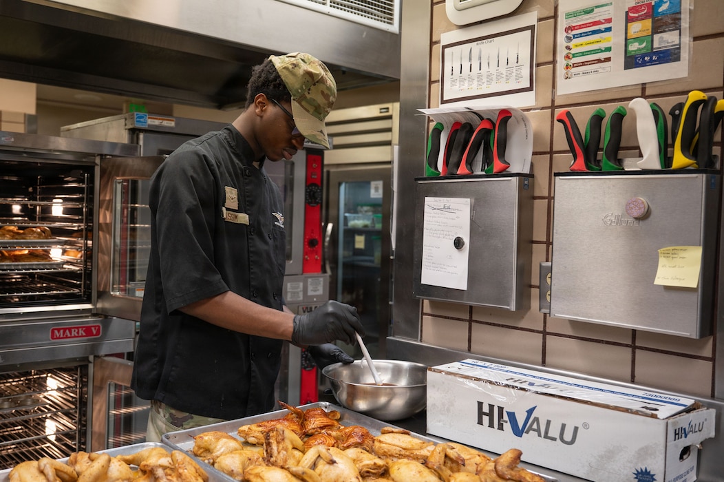 U.S. Air Force Airman Noah Kassim, 354th Force Support Squadron food services apprentice, glazes chicken at Eielson Air Force Base, Alaska, March 31, 2026.