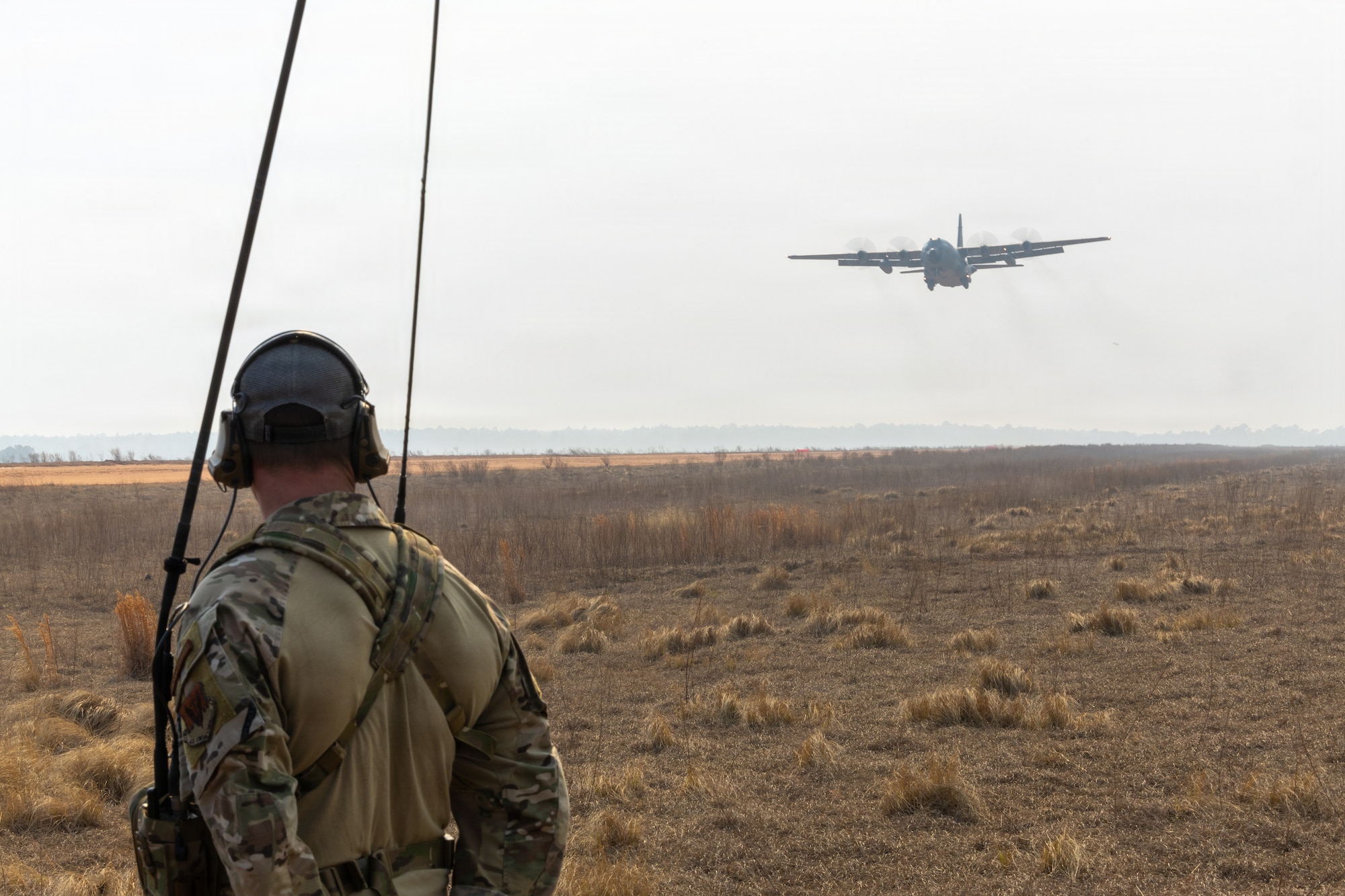 U.S. Air Force Master Sgt. Jacob A. Burkhalter, 235th Combat Airfield Operations Squadron (CAOS) flight chief of contingency airfield operations, oversees aircraft operations during a Landing Zone Safety Officer course at Holland Drop Zone, Fort Bragg, N.C., March 4, 2026.