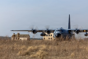 U.S. Air Force Tech. Sgt. Ethan O. Culliton, 352nd Special Warfare Training Squadron landing zone safety officer, left, oversee a Dutch pathfinder assigned to the 11th Air Assault Brigade, Royal Netherlands Army, right, marshal a U.S. C-130 Hercules to its assigned parking spot during a Landing Zone Safety Officer course at Holland Drop Zone, Fort Bragg, N.C., March 4, 2026.