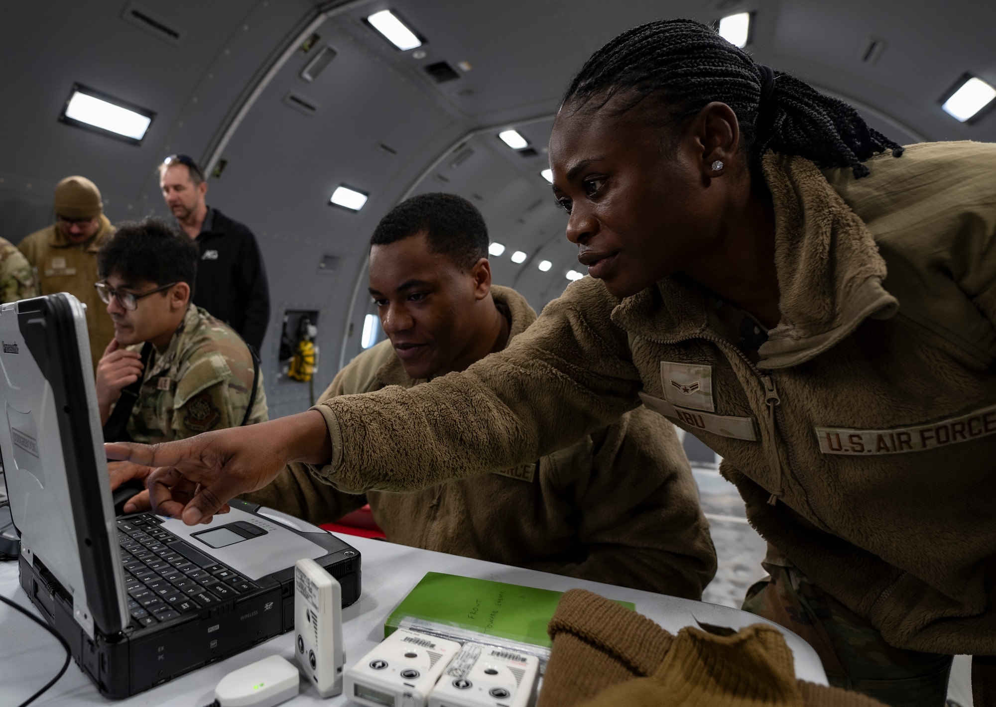 U.S. Air Force Airman 1st Class Samira Abu and Airman Jeremiah Mitchell, both 87th Operational Medical Readiness Squadron bioenvironmental engineering technicians, input radiation data from an electronic personal dosimeter during Radiant Falcon training at Joint Base McGuire-Dix-Lakehurst, N.J., March 26, 2026.