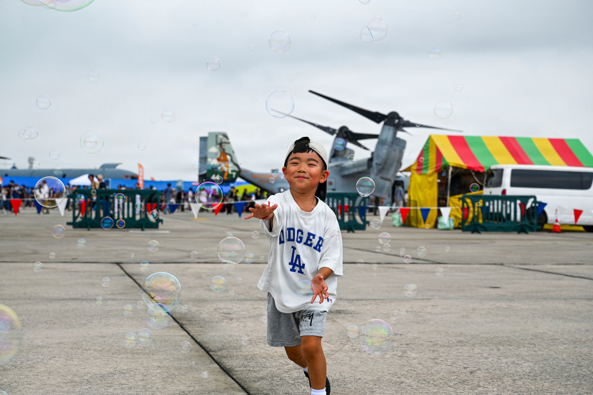 A festival attendee chases bubbles near the Sports Zone during America Fest 2026 at Kadena Air Base, Japan.