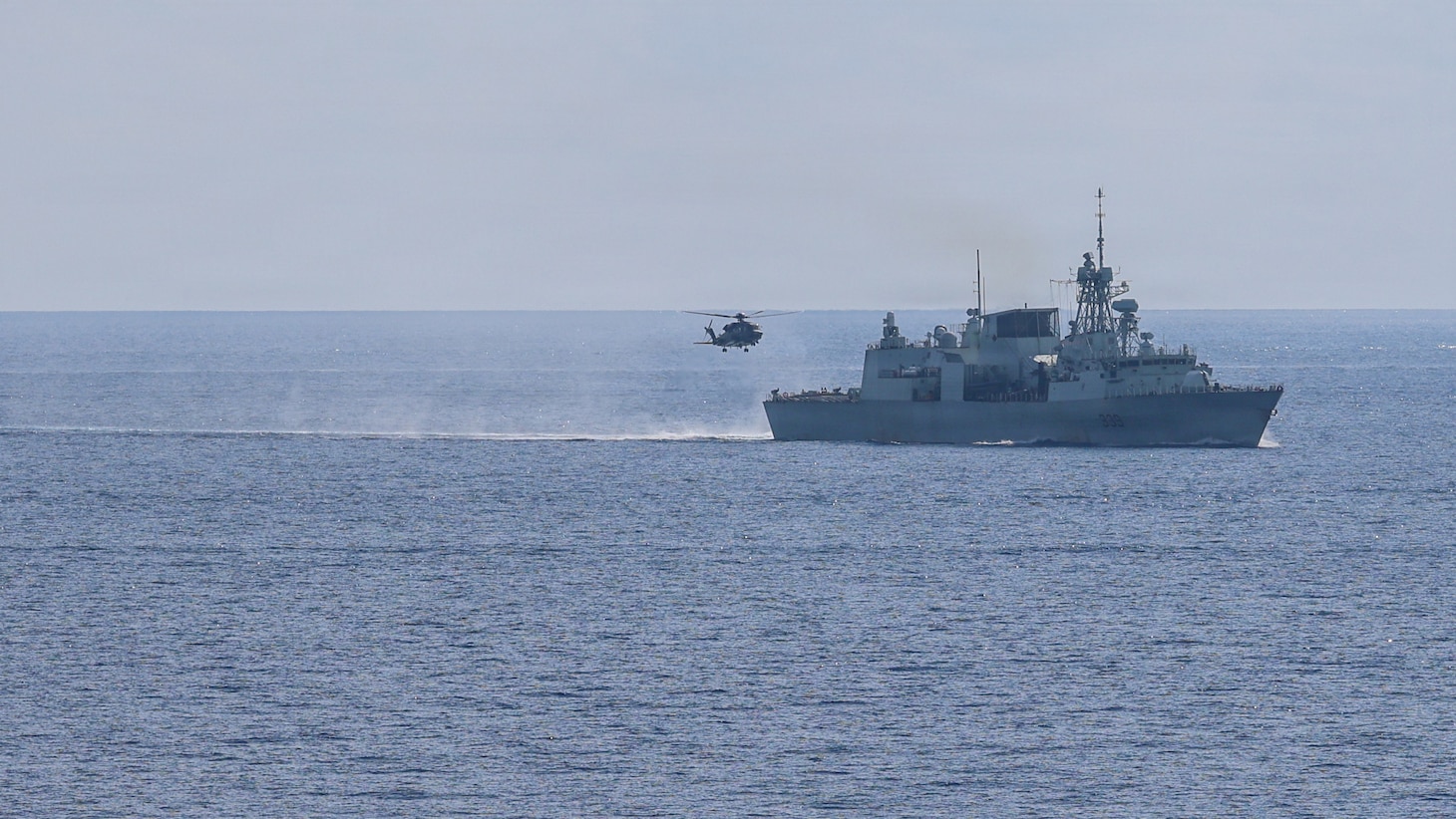 A Royal Canadian Air Force Super Puma lands on the flight deck of Halifax-class frigate HMCS Charlottetown (FFH 339) as the ship maneuvers into formation with Whidbey Island-class dock landing ship USS Ashland (LSD 48) after taking on fuel from Canadian supply ship MV Asterix during a multilateral exercise with the Royal Australian Navy and Royal Canadian Armed Forces in the South China Sea, April 14, 2026.