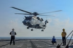 A Royal Canadian Air Force Super Puma assigned to Royal Canadian Navy Halifax-class frigate HMCS Charlottetown (FFH 339) prepares to land on the flight deck of U.S. Navy Whidbey Island-class dock landing ship USS Ashland (LSD 48) during a multilateral exercise with the Royal Australian Navy and Royal Canadian Armed Forces in the South China Sea, April 18, 2026.