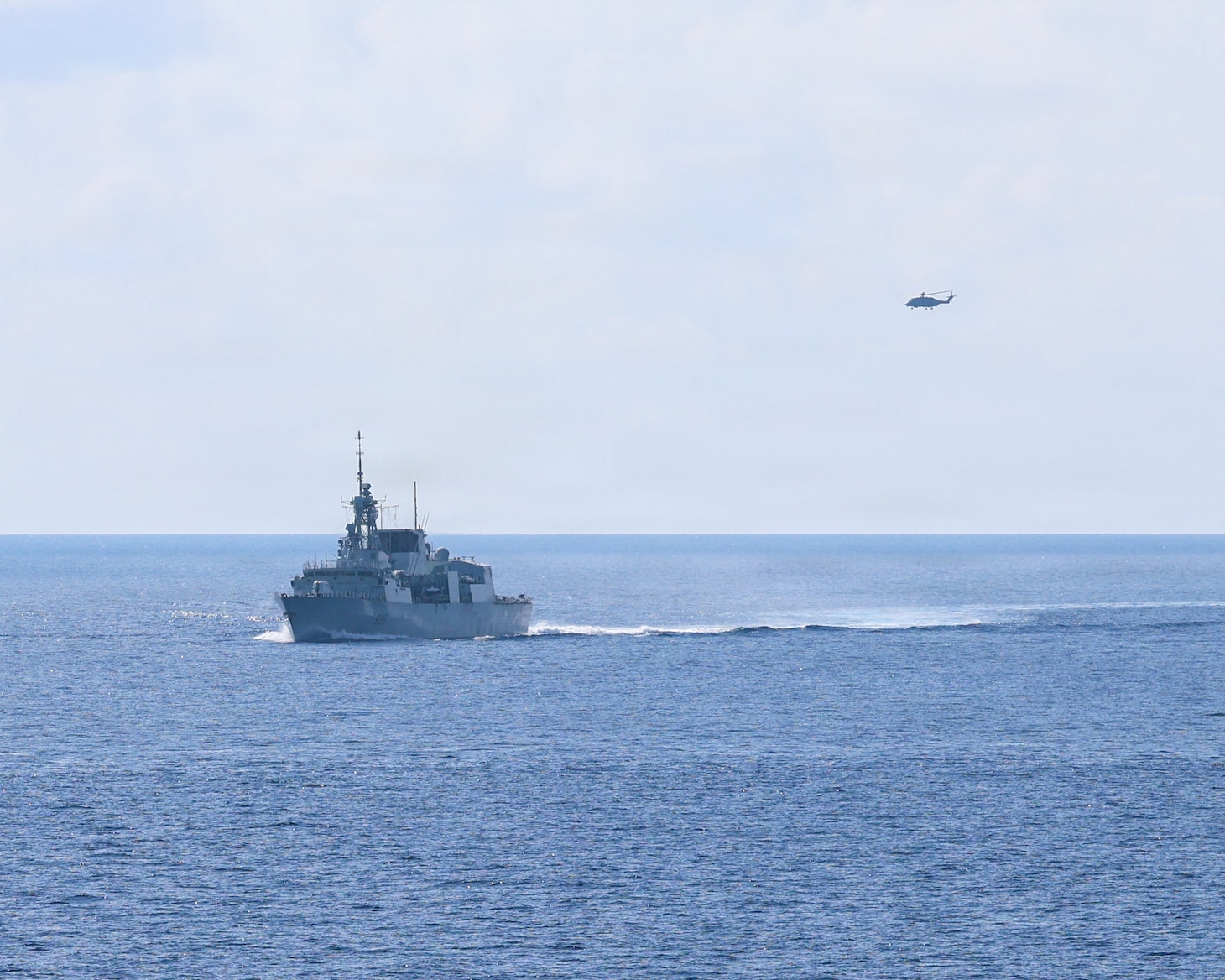 Royal Canadian Navy Halifax-class frigate HMCS Charlottetown (FFH 339) maneuvers into formation with Whidbey Island-class dock landing ship USS Ashland (LSD 48) after taking on fuel from Canadian supply ship MV Asterix during a multilateral exercise with the Royal Australian Navy and Royal Canadian Armed Forces in the South China Sea, April 14, 2026.