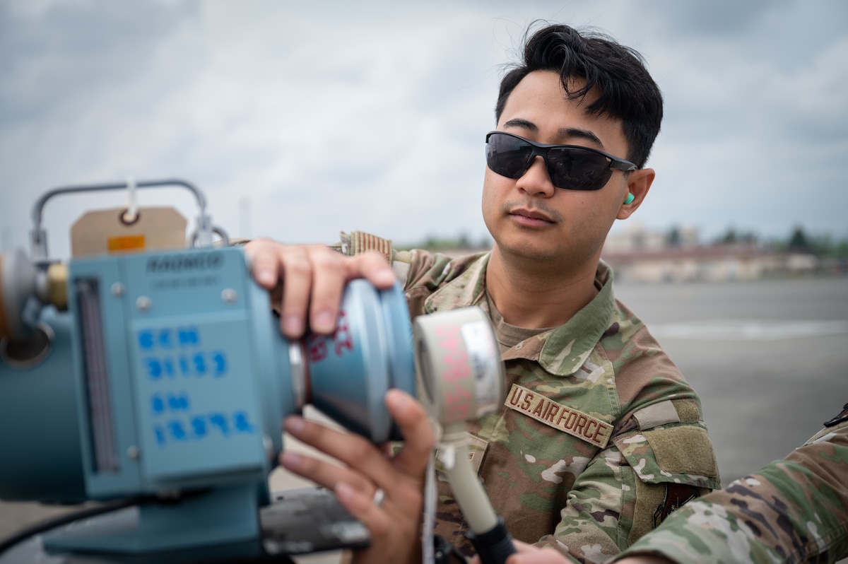 An Airman measures simulated radiation levels.