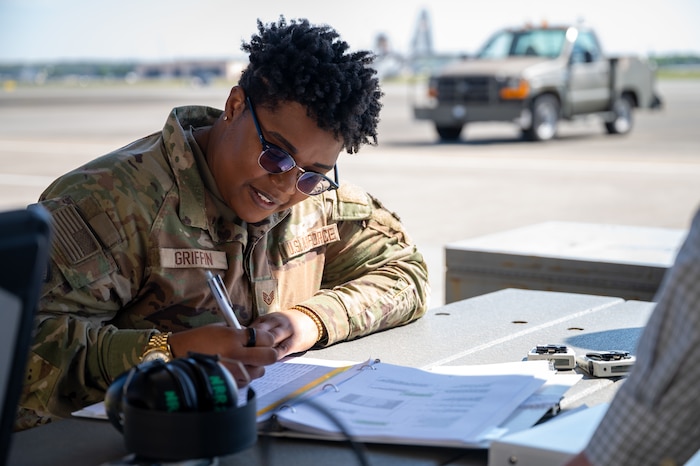 An Airman writes data on a spreadsheet.