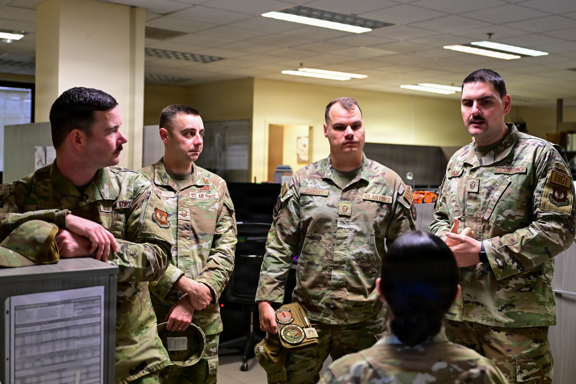U.S. Air Force first sergeants assigned to the 31st Fighter Wing speak with Airman 1st Class Kyree-Lee Graves, 31st Force Support Squadron outbound assignments counselor, during a visit to an FSS work center at Aviano Air Base, Italy, March 26, 2026.