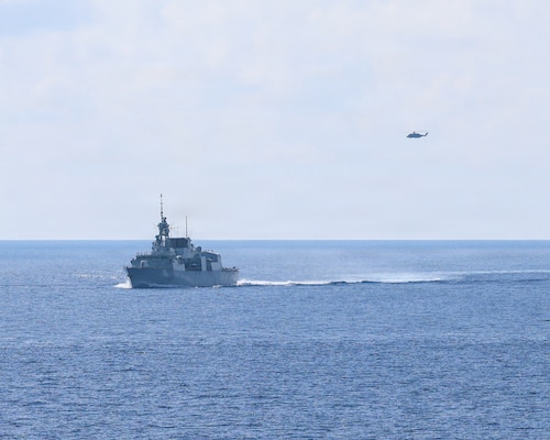 Royal Canadian Navy Halifax-class frigate HMCS Charlottetown (FFH 339) maneuvers into formation with Whidbey Island-class dock landing ship USS Ashland (LSD 48) after taking on fuel from Canadian supply ship MV Asterix during a multilateral exercise with the Royal Australian Navy and Royal Canadian Armed Forces in the South China Sea, April 14, 2026.