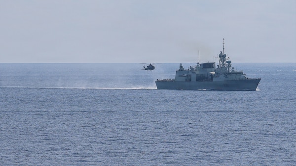 A Royal Canadian Air Force Super Puma lands on the flight deck of Halifax-class frigate HMCS Charlottetown (FFH 339) as the ship maneuvers into formation with Whidbey Island-class dock landing ship USS Ashland (LSD 48) after taking on fuel from Canadian supply ship MV Asterix during a multilateral exercise with the Royal Australian Navy and Royal Canadian Armed Forces in the South China Sea, April 14, 2026.