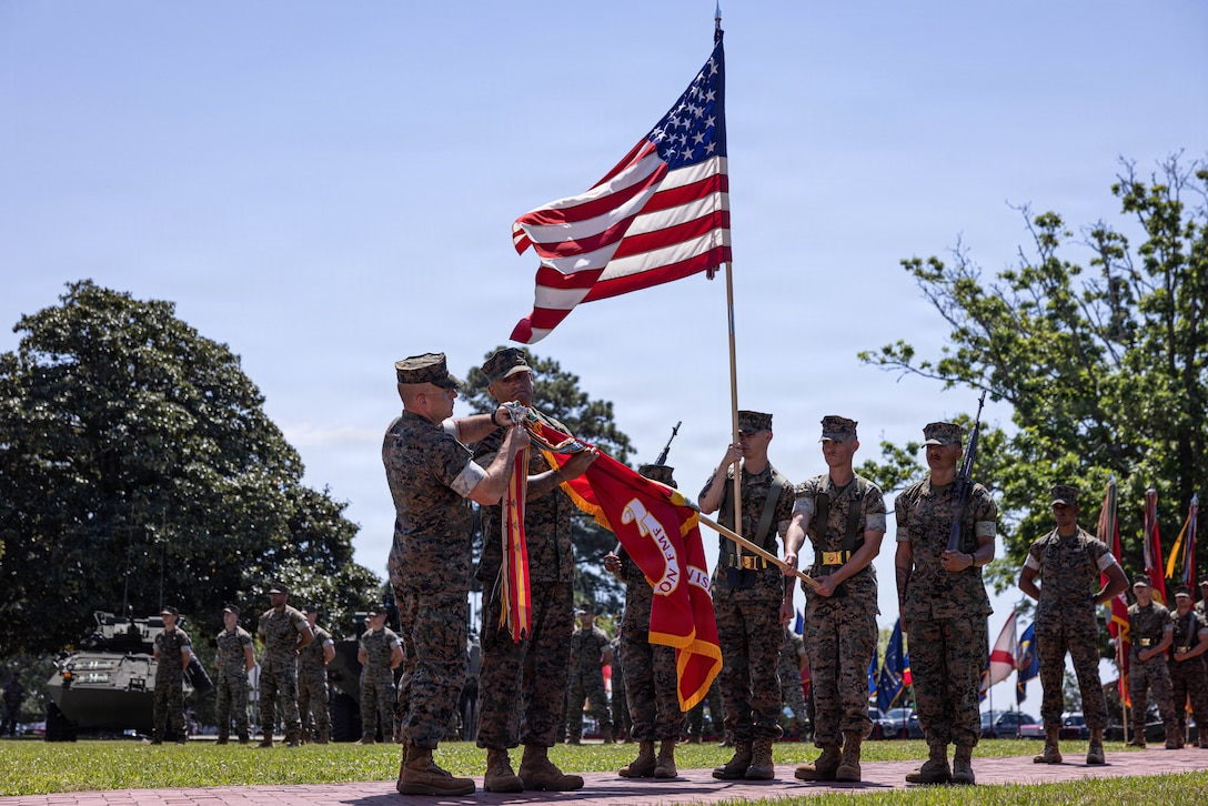 U.S. Marine Corps Maj. Gen. Farrell J. Sullivan, the commanding general of the 2nd Marine Division, and Sgt. Maj. Joseph Mendez, the sergeant major of 2nd MARDIV, attach a campaign streamer to the division colors during a division rededication ceremony on Marine Corps Base Camp Lejeune, North Carolina, April 17, 2026. The ceremony honored the 85th birthday by reflecting the esprit de corps and brotherhood within 2nd MARDIV and pays homage to the service and sacrifice of Marines and Sailors both past and present. (U.S. Marine Corps photo by Cpl. Judith Ann Lazaro)