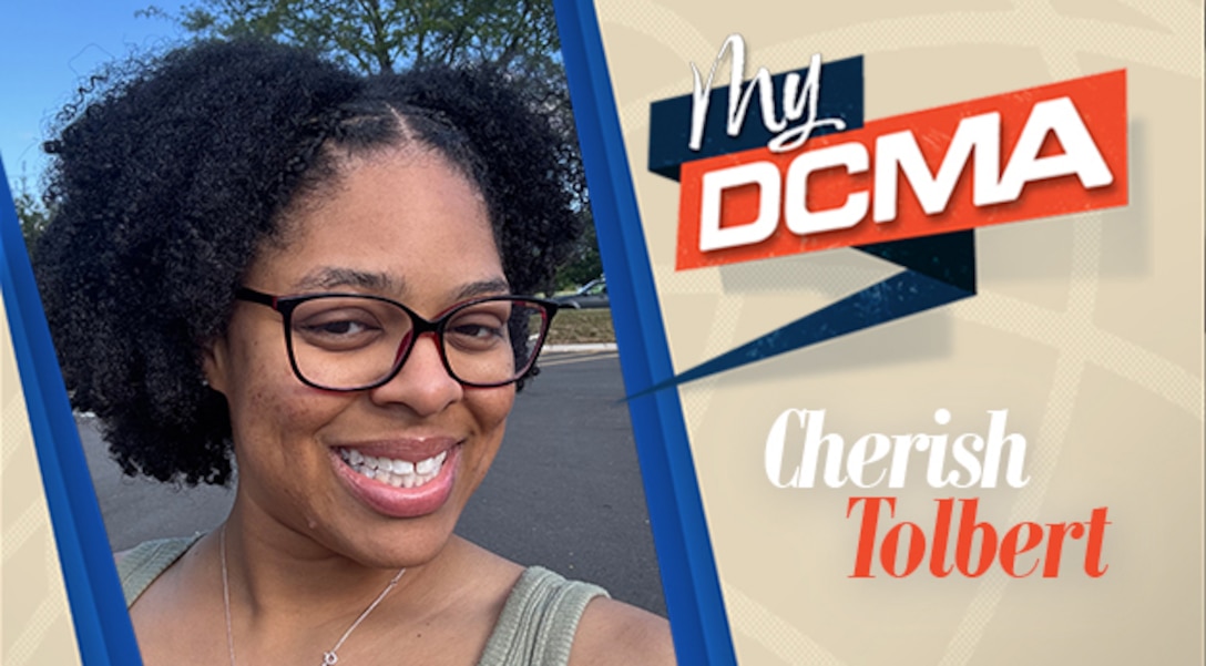 Smiling woman wears black glasses and green shirt