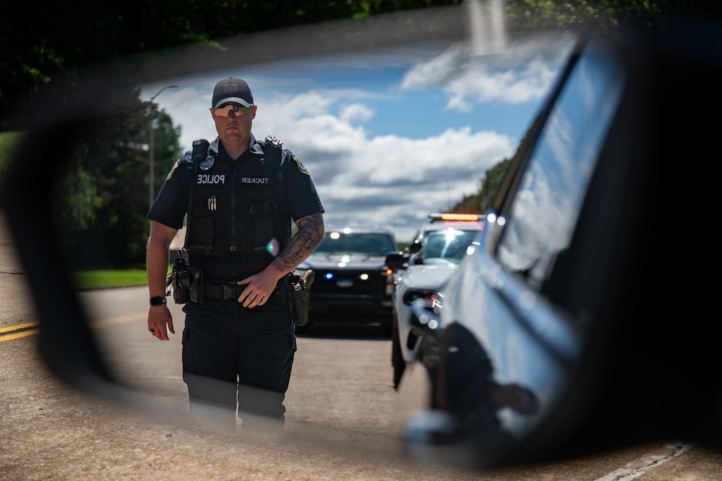 Officer Garrett Tucker with the Arnold Air Force Base Police Department approaches a vehicle during a simulated stop May 12, 2025, at Arnold AFB. The Arnold Engineering Development Complex Safety team is asking fellow team members across the Complex to take steps to prevent distracted driving. (U.S. Air Force photo by Keith Thornburgh)