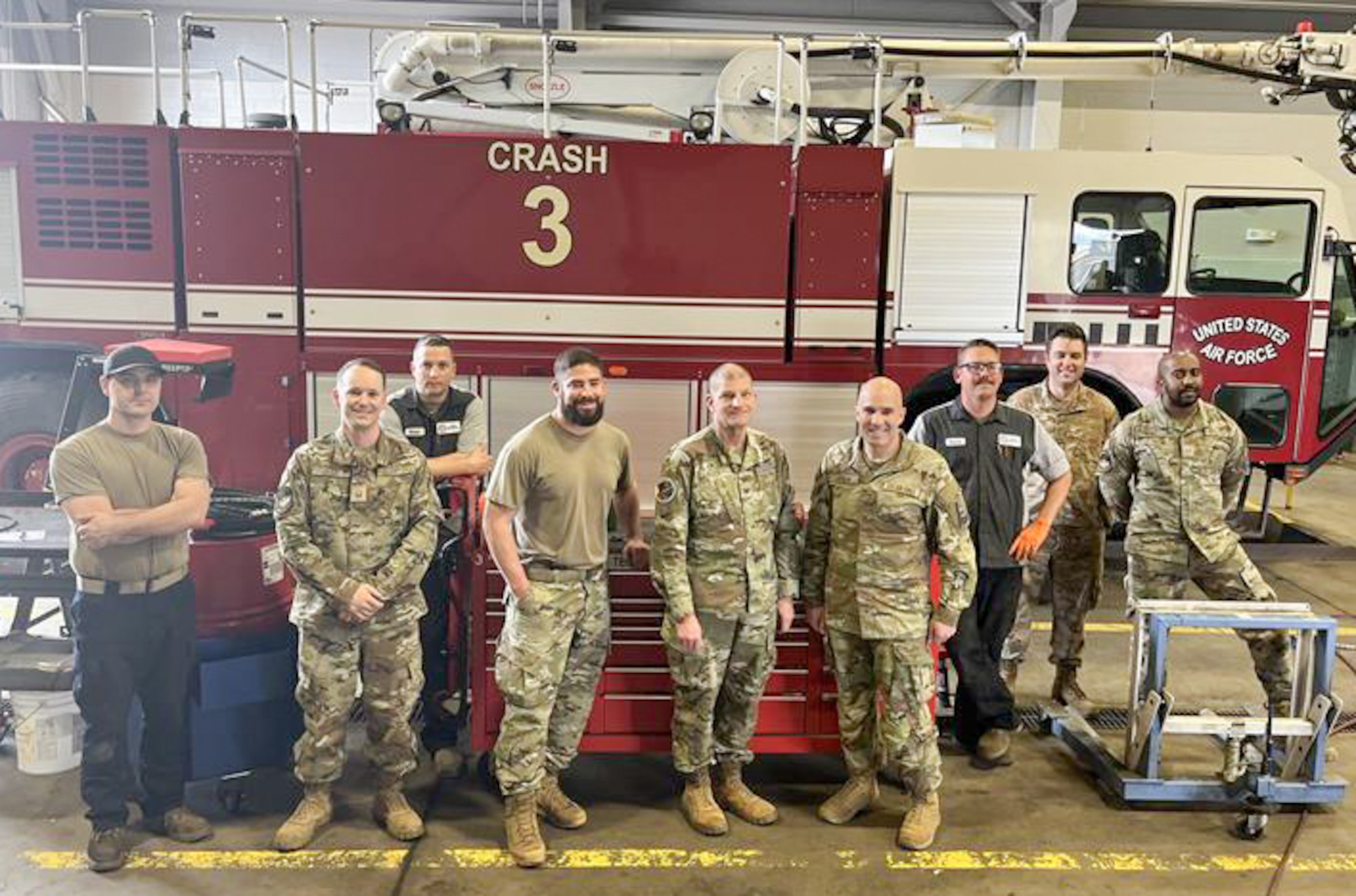 Col. Klock and Chief Master Sgt. Joslin stand in a group in front of a fire truck with members of the 21st Logistics Readiness Squadron.