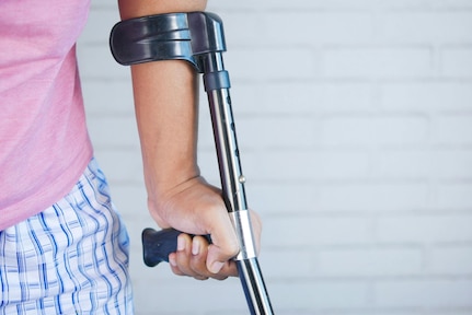 The left arm of a person using a crutch to walk.