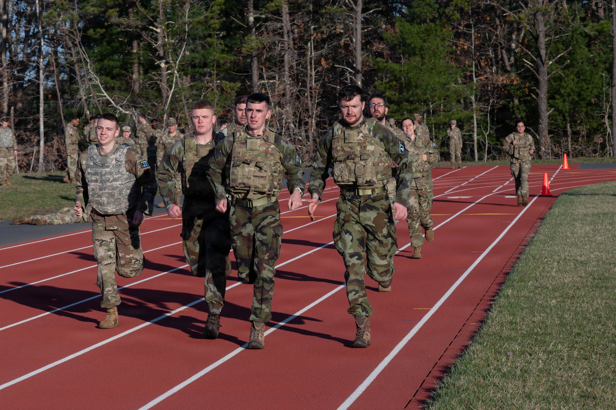 Airmen and Irish Defence Forces Soldiers run on a track.