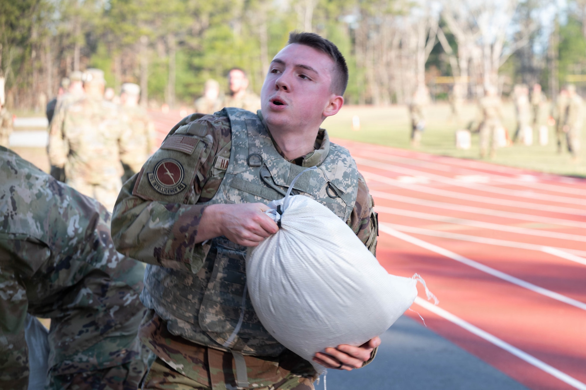 Airman lifts a sandbag.