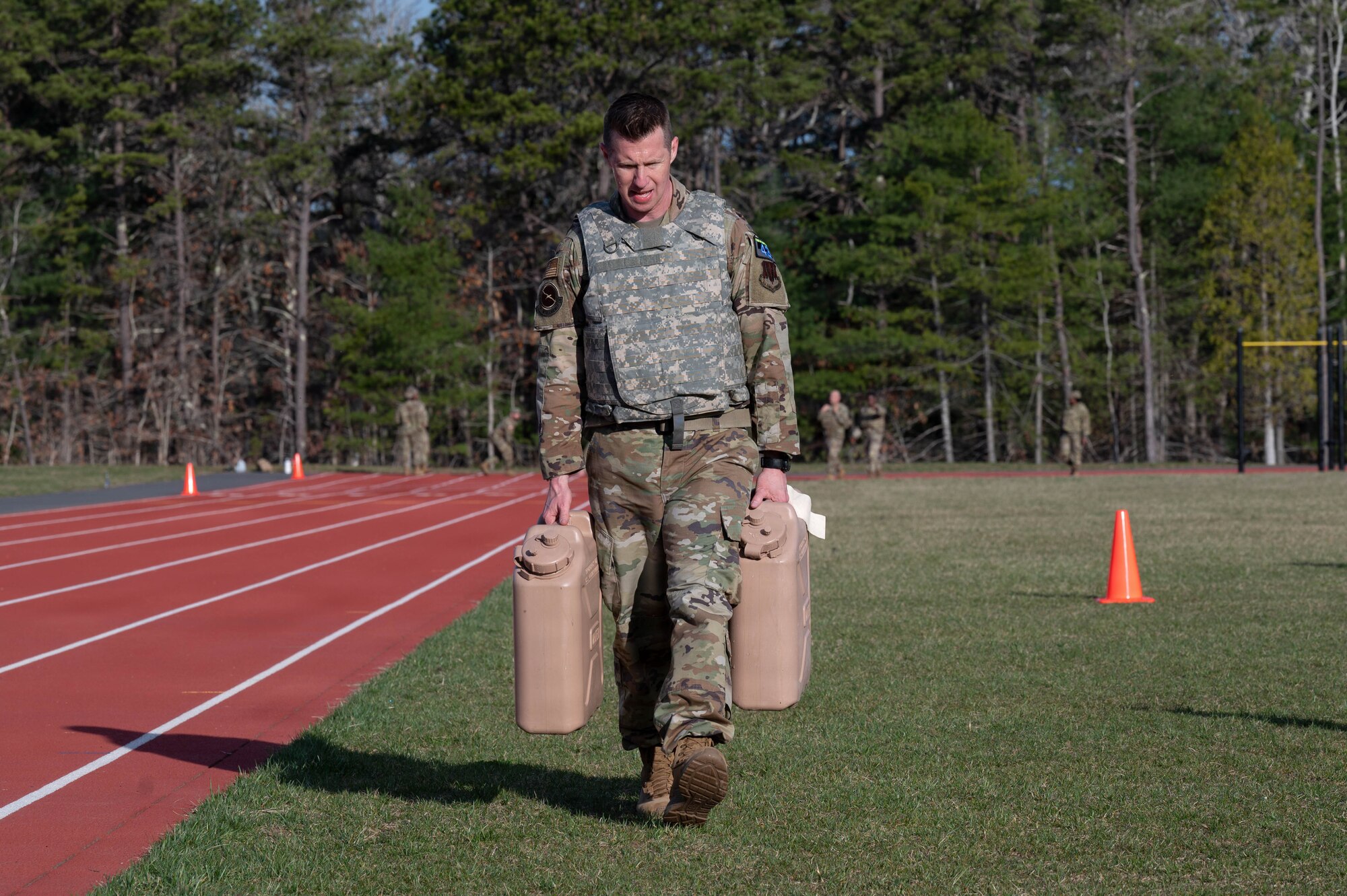 Airman carries jugs.