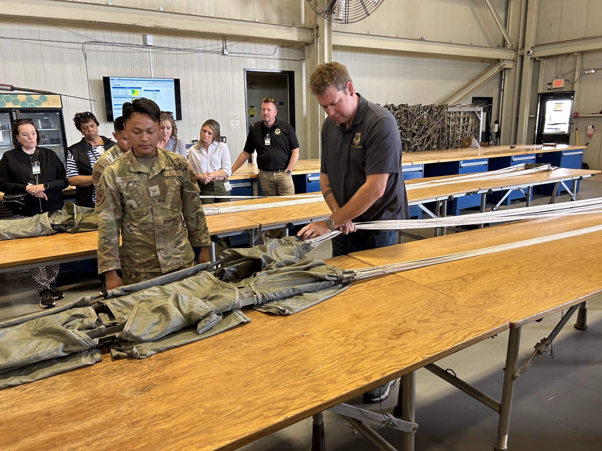 Mark Sutherland, Air Mobility Command civic leader, participates in an interactive parachute building demonstration with Airmen assigned to the 97th Logistics Readiness Squadron at Altus Air Force Base, Oklahoma, April 9, 2026. (Courtesy photo)