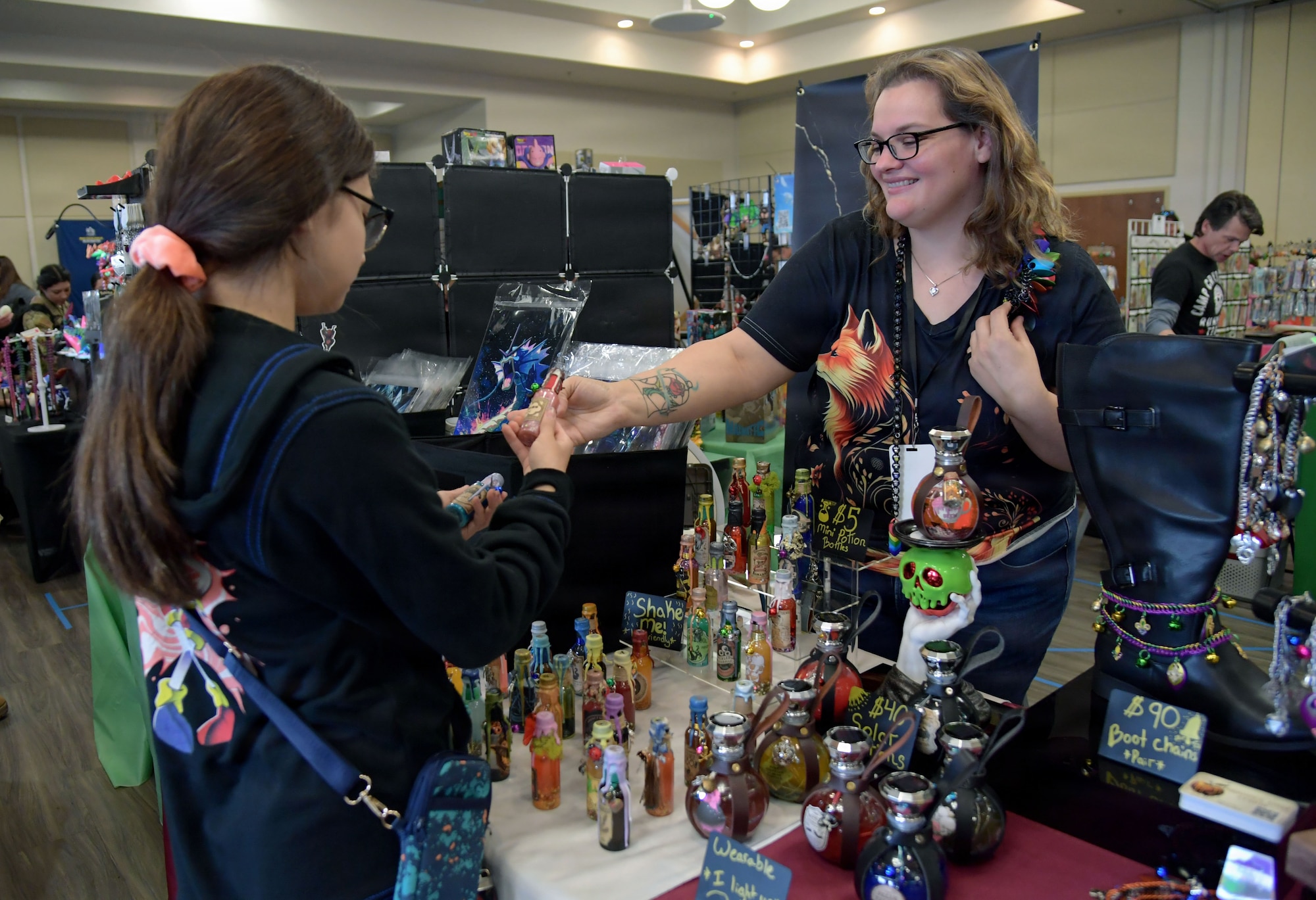 A woman gives a small vase to a young lady.