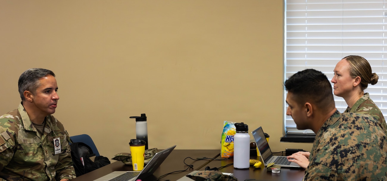 U.S. Air Force Master Sgt. Paisley Majewski, 23d Wing inspector general team lead, right; U.S. Marine Corps 1st Lt. John Litton, Marine Wing Support Squadron (MWSS) 273 communication officer; and U.S. Air Force Col. Hiram Ortiz, 23d Wing inspector general, discuss joint operations during Exercise Ready Tiger 26-3 at Savannah Air National Guard Base, Georgia, April 15, 2026. Joint collaboration during training exercises allows units to seamlessly integrate capabilities, strengthen interoperability and generate combat-ready power. The exercise advanced integrated operations across units to deliver combat power when and where it was needed. (U.S. Air Force photo by Senior Airman Victoria Moehlman)