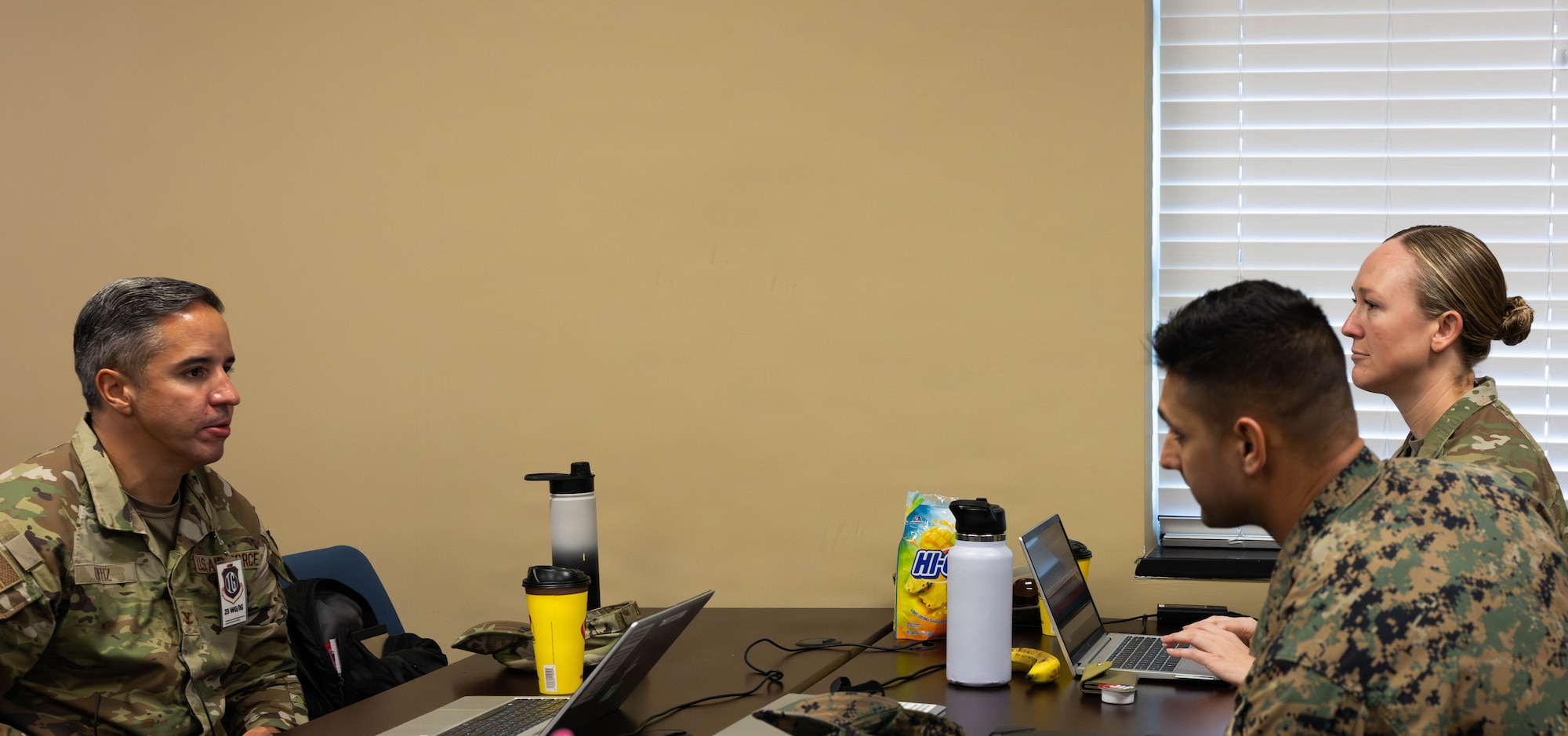 U.S. Air Force Master Sgt. Paisley Majewski, 23d Wing inspector general team lead, right; U.S. Marine Corps 1st Lt. John Litton, Marine Wing Support Squadron (MWSS) 273 communication officer; and U.S. Air Force Col. Hiram Ortiz, 23d Wing inspector general, discuss joint operations during Exercise Ready Tiger 26-3 at Savannah Air National Guard Base, Georgia, April 15, 2026. Joint collaboration during training exercises allows units to seamlessly integrate capabilities, strengthen interoperability and generate combat-ready power. The exercise advanced integrated operations across units to deliver combat power when and where it was needed. (U.S. Air Force photo by Senior Airman Victoria Moehlman)