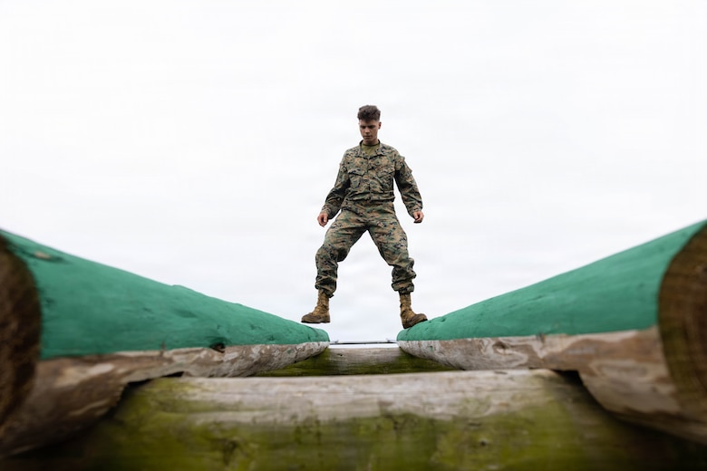 U.S. Marine Corps Joseph Kreis, a combat photographer with Headquarters and Support Battalion, Marine Corps Installations Pacific, walks down on logs during an O-Course physical training event during a field training exercise on Camp Hansen, Okinawa, Japan, Apr. 6, 2026. TThe COMMSTRAT FTX is a five-day event focused on increasing acumen and technical proficiency to provide commanders with capable COMMSTRAT forces at the tactical level. (U.S. Marine Corps photo by Lance Cpl. Carlos Paz-Sosa) 
“I feel a great sense of accomplishment because when I was in boot camp I couldn’t actually finish it,” said Kries. “I couldn’t climb the rope, I struggled climbing over the bar. Now I feel that sense of accomplishment knowing I can actually complete the obstacle course.”
Kreis expressed his excitement about his progression throughout his career. From recruit training to now Kreis has proved to himself that he has progressed in physical and mental challenges.  Kreis is a native of Virginia.