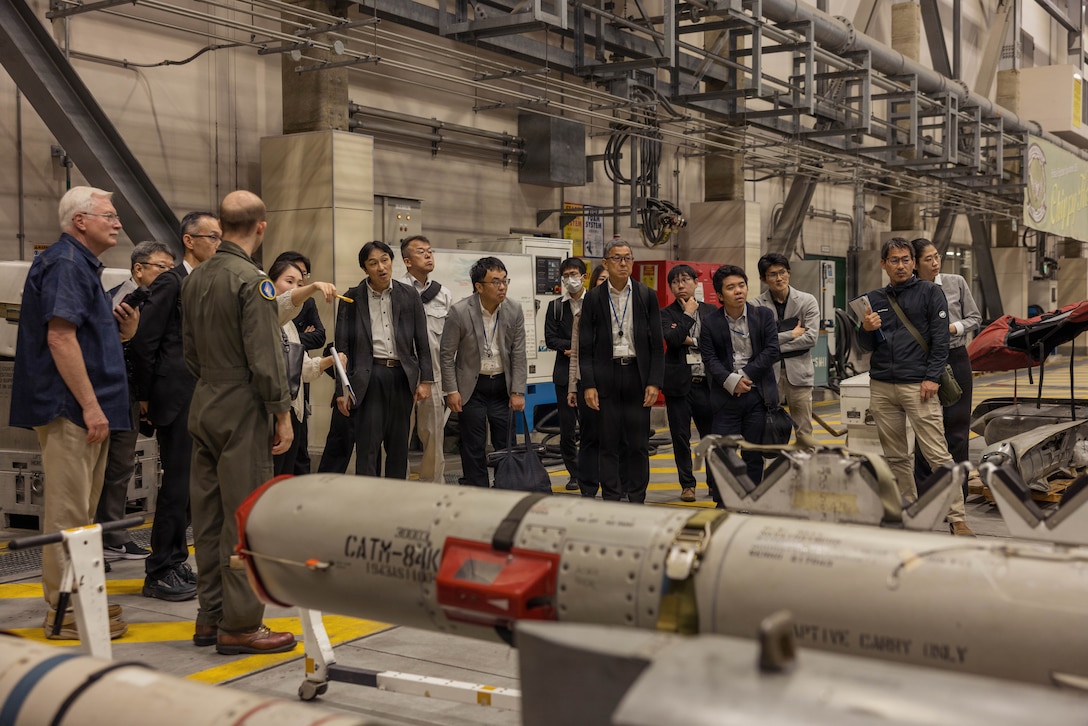 Chugoku-Shikoku Defense Bureau members observe a U.S. Navy F/A-18E Super Hornet aircraft assigned to Strike Fighter Squadron (VFA) 195, Carrier Air Wing 5, during a base tour at Marine Corps Air Station Iwakuni, Japan, April 14, 2026. The tour provided the members of CSDB a better understanding of the complexity of Naval Aviation maintenance and supply by allowing them to get close to the aircraft and be able to speak with Sailors. (U.S. Marine Corps photo by Cpl. Sarah M. Grawcock)