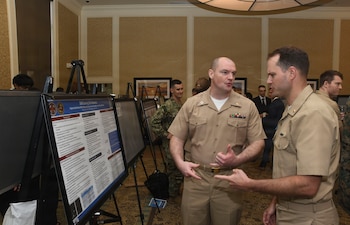 Navy Lt. Ryan Blank with Naval Medical Center Camp Lejeune's Family Medicine Residency Program discusses his research poster at NMCCL’s Annual Research Symposium on April 16, 2026, at Camp Lejeune, North Carolina.