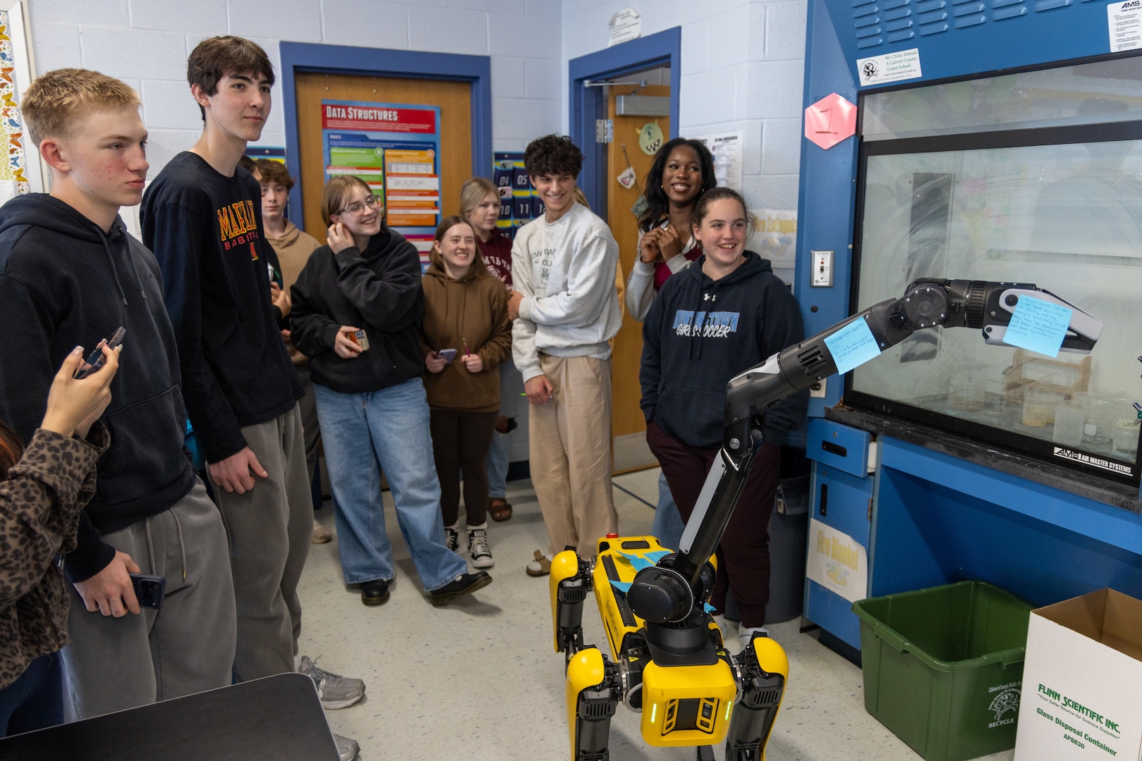 Students at the Calvert County Mathematics, Engineering, Science Achievement (MESA) Day at Huntingtown High School interact with a Boston Dynamics robot dog.