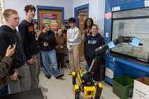 Students at the Calvert County Mathematics, Engineering, Science Achievement (MESA) Day at Huntingtown High School interact with a Boston Dynamics robot dog.