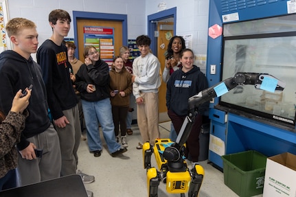 Students at the Calvert County Mathematics, Engineering, Science Achievement (MESA) Day at Huntingtown High School interact with a Boston Dynamics robot dog.