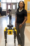 Dr. Crystal M. Ricks, the Supervisor of Gifted, Advanced Learning, Articulation, STEM & MESA, and Robotics Competition, poses with a Boston Dynamics robot dog