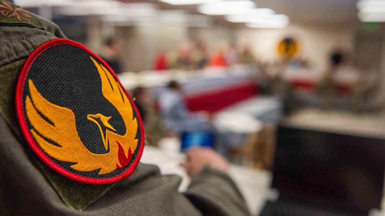 Close up of unit patch as Airman listens to presentation