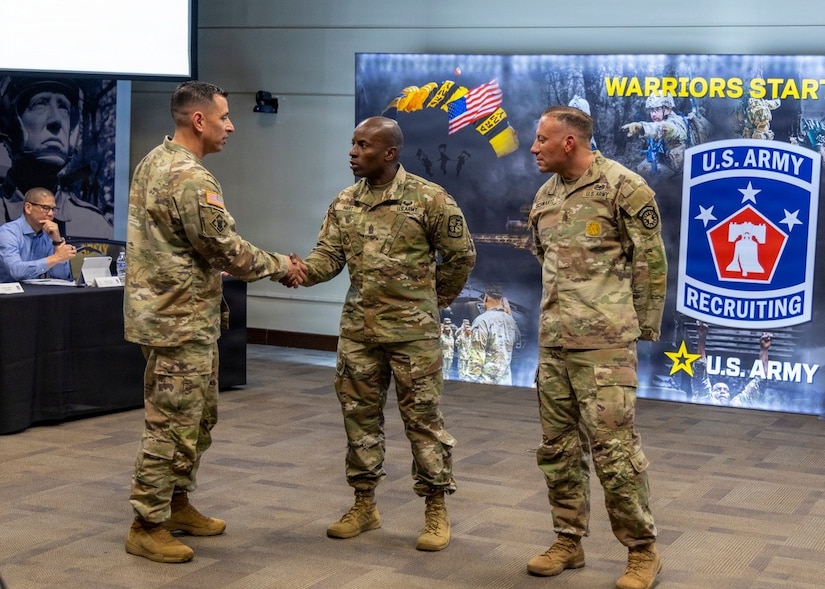 Command Sgt. Maj. Shade S. Munday, senior enlisted leader for U.S. Army Recruiting Command, presents a challenge coin to Command Sgt. Maj. Dwight K. Hart, 7th Brigade, U.S. Army Cadet Command, during the U.S. Army Recruiting Command Senior Leader Forum at the Patton Museum, Fort Knox, Kentucky, April 16, 2026.