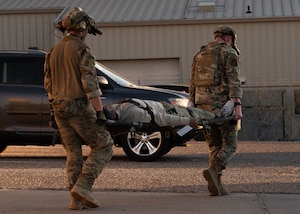 Two U.S. Air Force Pararescuemen assigned to the 68th Rescue Squadron carry a simulated casualty from an extraction point during the Combat Leader Course at Davis-Monthan Air Force Base, Arizona,  April 17, 2026. Pararescuemen are required to use a combination of leadership skills while in a high-stress environment in order to ensure mission success. (U.S. Air Force by Airman Najzee Kuzu)