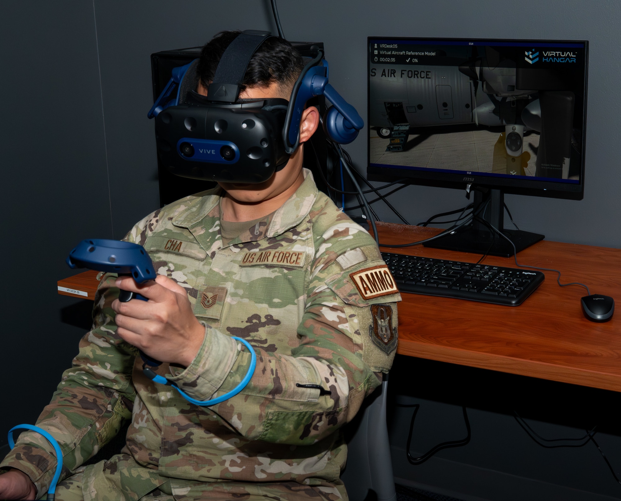 A military member holding a controller in each hand, wearing a VR headset.