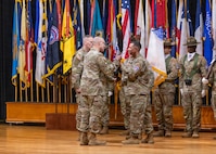 Command Sgt. Maj. Shade S. Munday, outgoing command sergeant major of U.S. Army Recruiting Command, passes the command colors to Lt. Gen. Johnny K. Davis, commanding general of U.S. Army Recruiting Command, during a change of responsibility ceremony at Waybur Theater, Fort Knox, Kentucky, April 17, 2026.