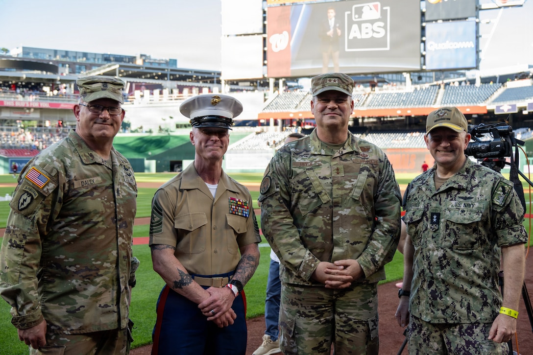 Four service joint leaders take group photo on feild.