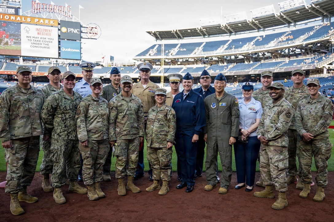 Service members take group photo on the feild.