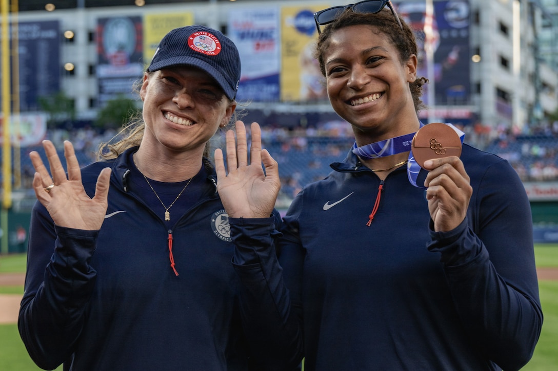 two women smile at camera.