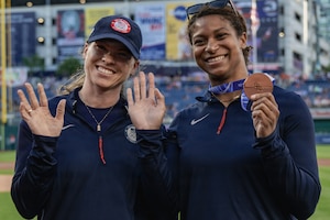 two women smile at camera.