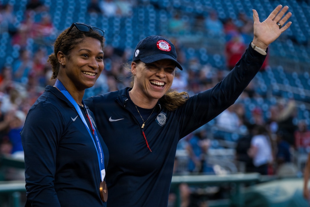 Two women wave to a crowd.