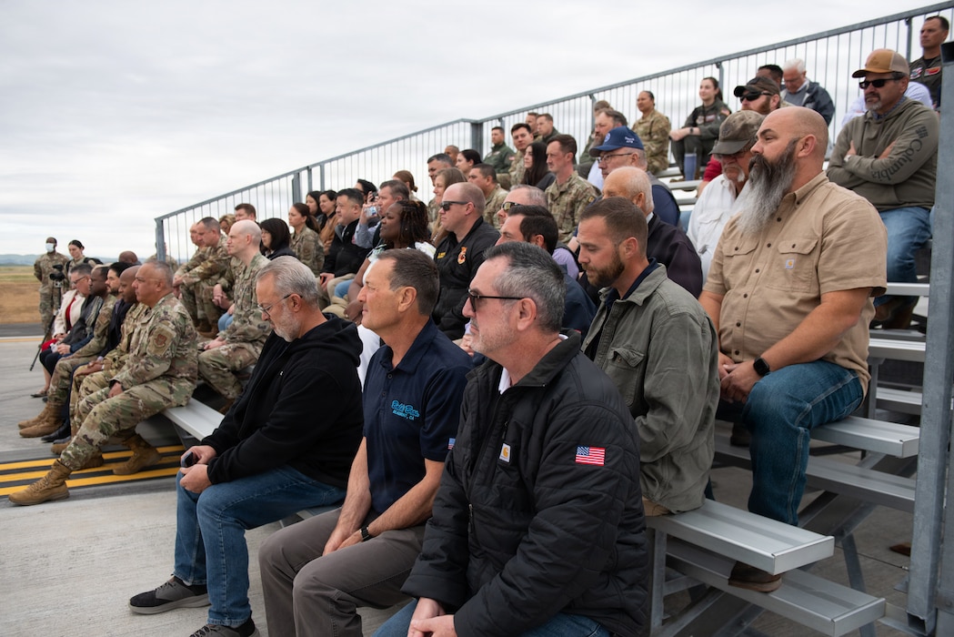 Attendees listen to wing commander deliver remarks during ceremony